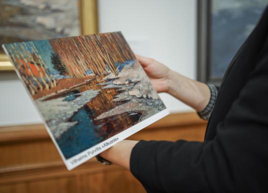 Persona tur rokās reljefa attēlu ar Vilhelma Purvīša gleznu “Atkusnis”, kas paredzēts taustes uztverei muzeja pieejamības programmas ietvaros.